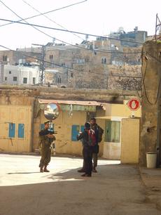 My cameraman being stopped for questioning by Israeli soldiers patrolling Al Shuhada street of Hebron's Old City. We were on our way to the Avraham Avinu Jewish settlement, established next to the The Abraham Avinu Synagogue built in the Jewish Quarter of Hebron in 1540. The Avraham Avinu settlement was established next to a Palestinian Vegetable and Wholesale Markets on the Al-Shuhada Street.This street was shut down by the Israeli military after numerous terror attacks against Jews.Brad, myself and my cameraman were the only ones on the street. Israel captured Hebron in the Six Day War in 1967.photo by Rhonda Spivak